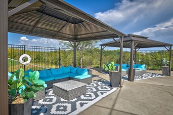 a covered patio with blue couches and a pavilion